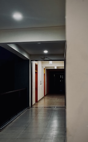 A dimly lit hotel corridor with flickering lights and empty hallways.