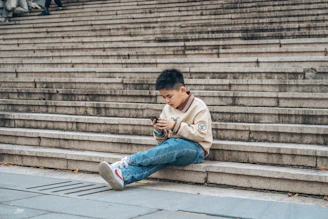 A child using a low-end smartphone to follow a coding lesson in a rural Kenyan setting.