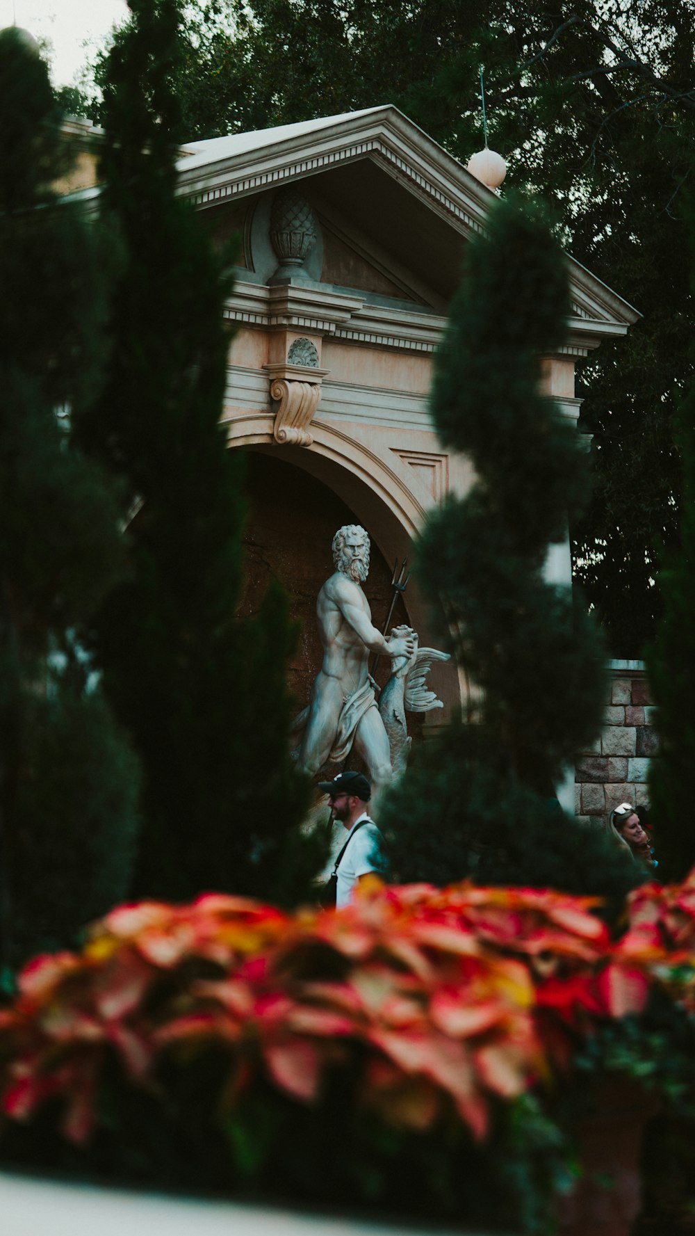 eine Statue einer Person, die eine Fackel vor einem Gebäude hält