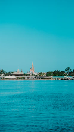 A vibrant collage showing Walt Disney World castle, Universal Studios globe, and a luxury cruise ship sailing under a clear blue sky.