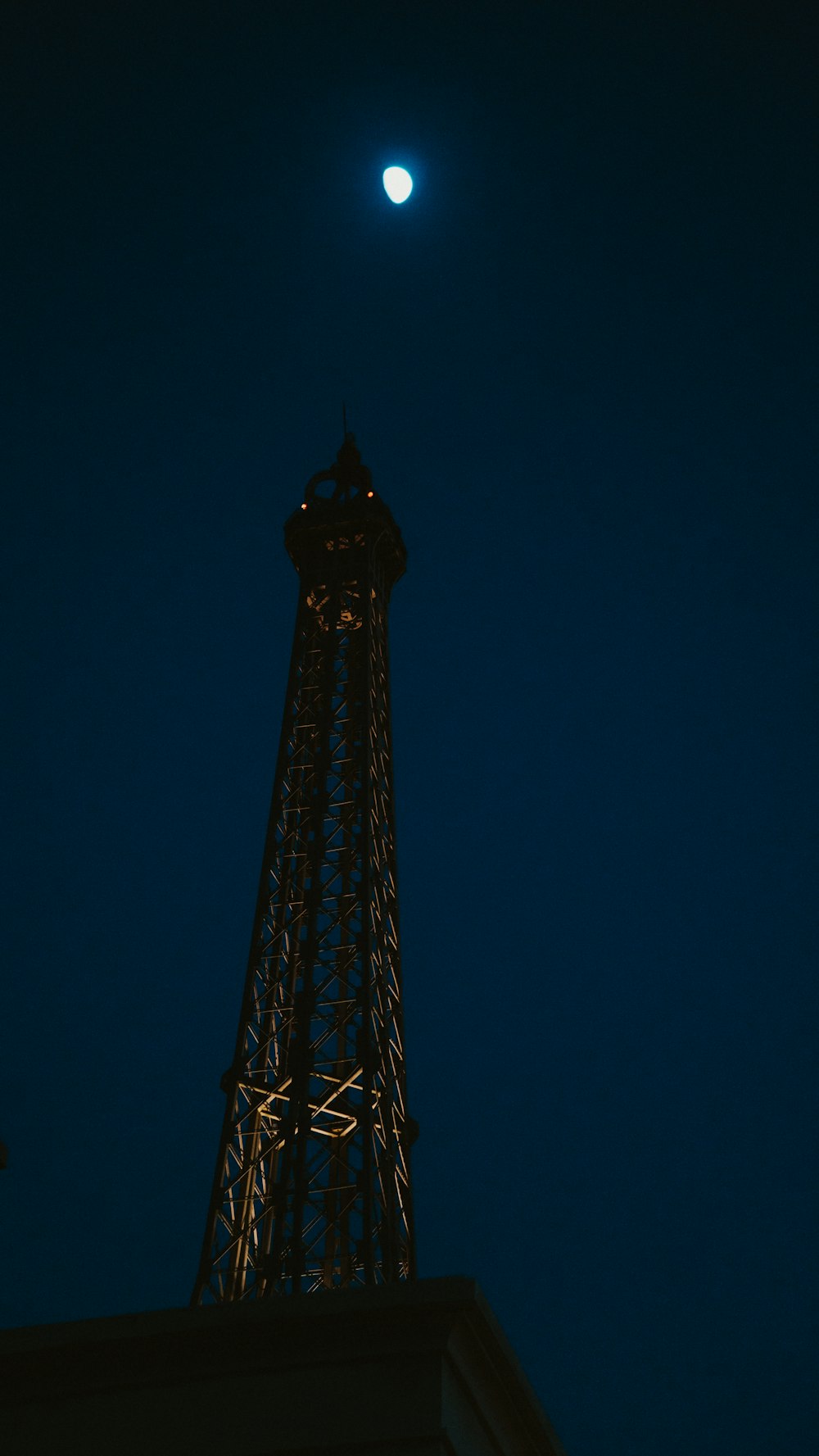 a tall tower with a moon in the sky
