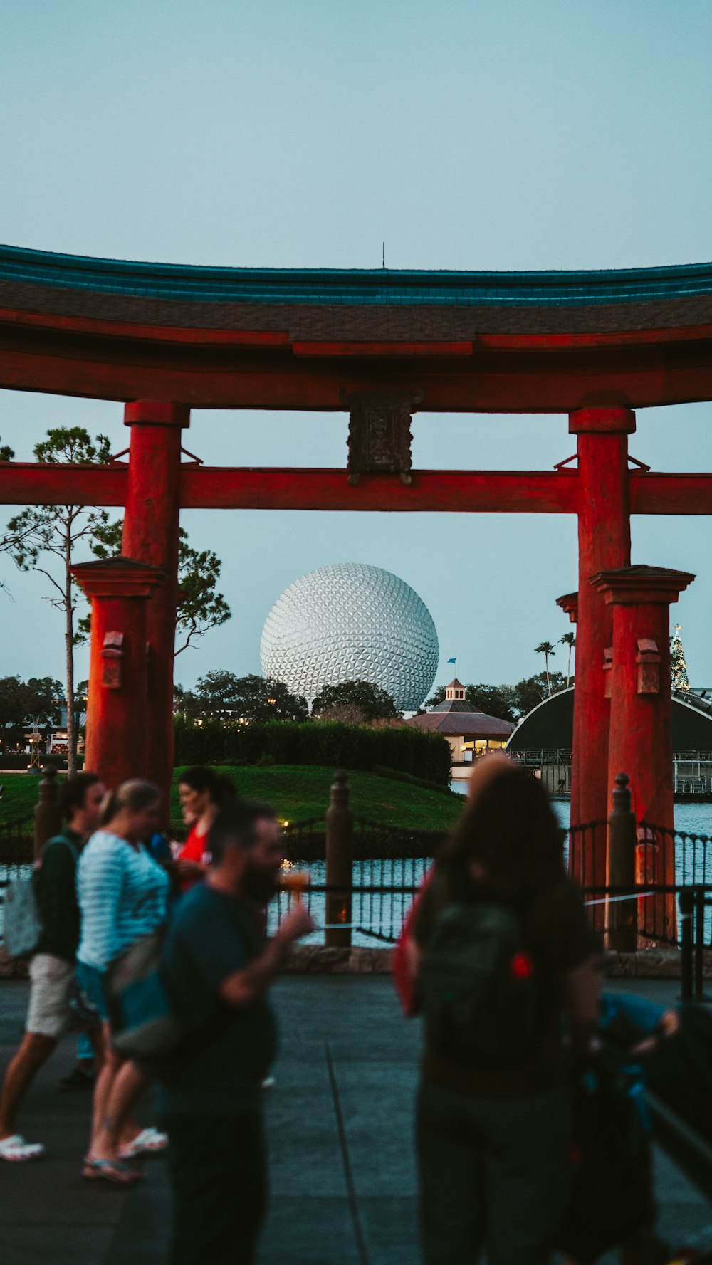 a group of people standing under a red structure