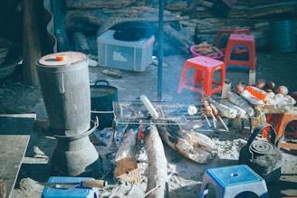 Outdoor cooking setup with fire safety equipment in a prefabricated shelter.
