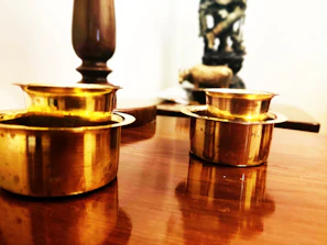 Brass cups and serving spoons reflecting warm light, highlighting their handcrafted details