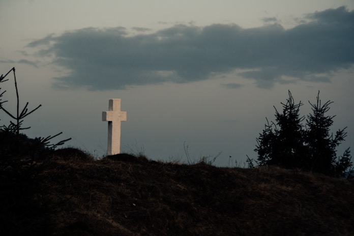 a white cross on a hill