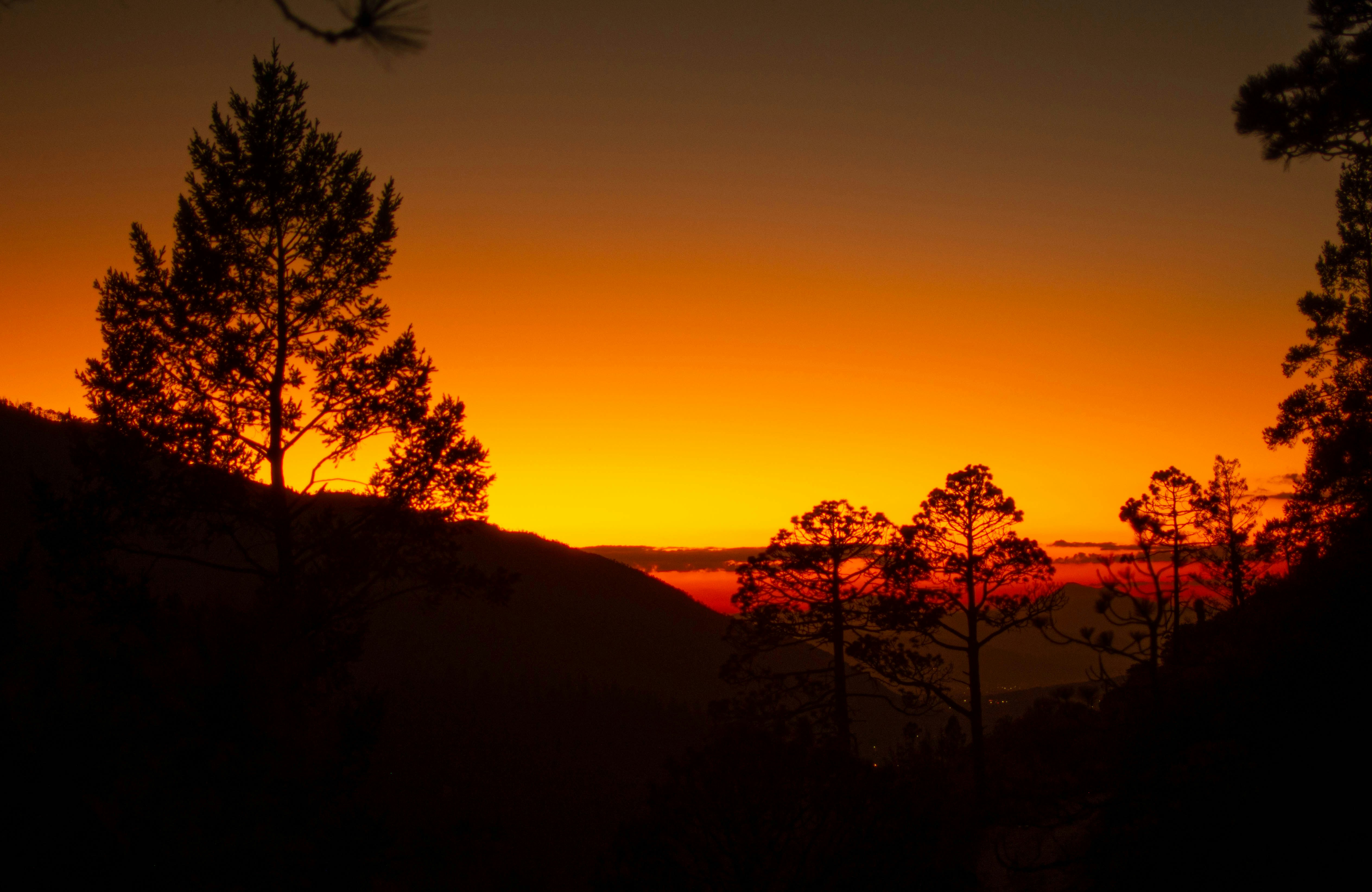 a sunset over a hill
