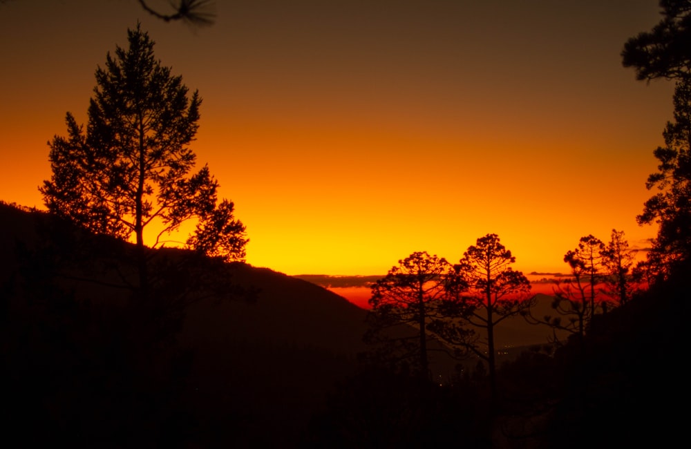 a sunset over a hill