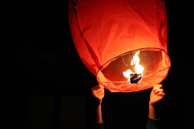 Close-up of hands releasing a paper bird into the sky, symbolizing emotional liberation.