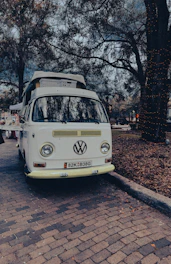 A vintage 1967 VW T1 Samba bus parked in a scenic outdoor setting, ready for a wedding.