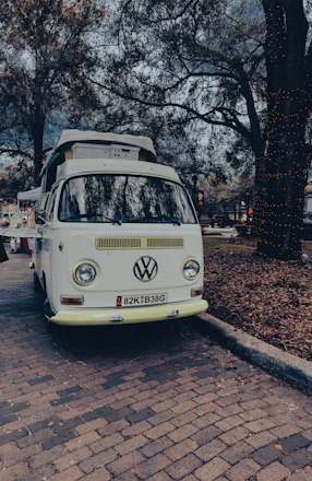 A vintage 1967 VW T1 Samba bus parked in a scenic outdoor setting, ready for a wedding.