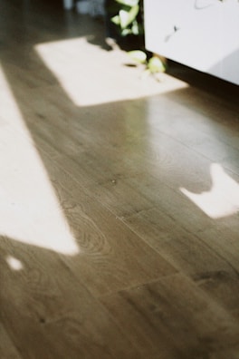 A newly finished hardwood floor reflecting natural light in a living space.