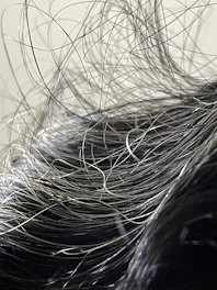 Close-up of silky, natural human hair strands flowing smoothly.