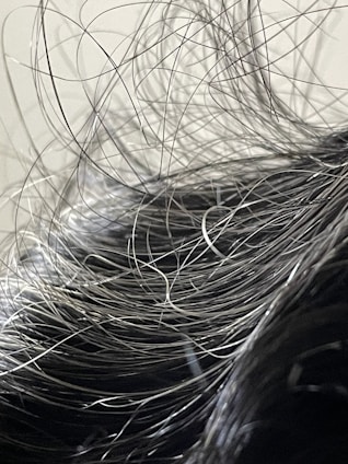 A serene close-up of healthy hair strands resting on a soft, neutral-toned fabric background.