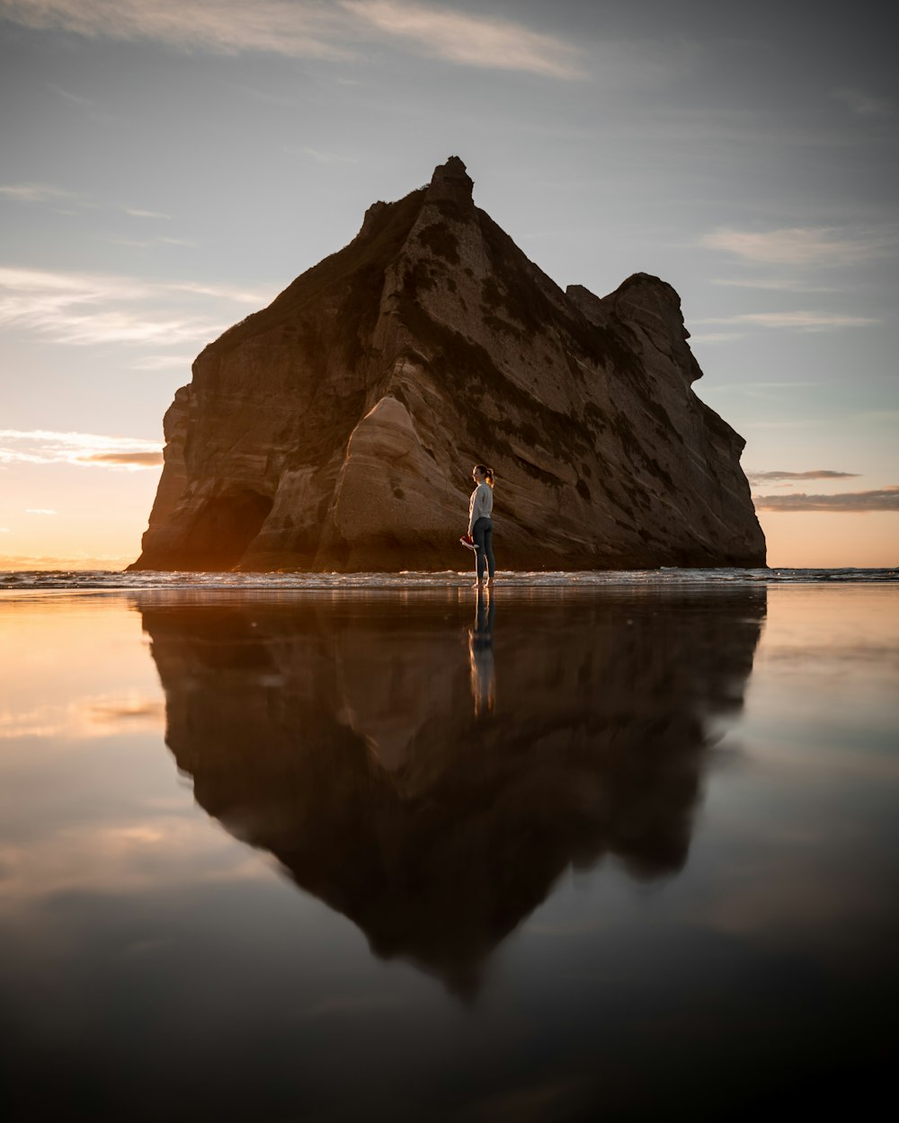 a person standing on a rock in the water