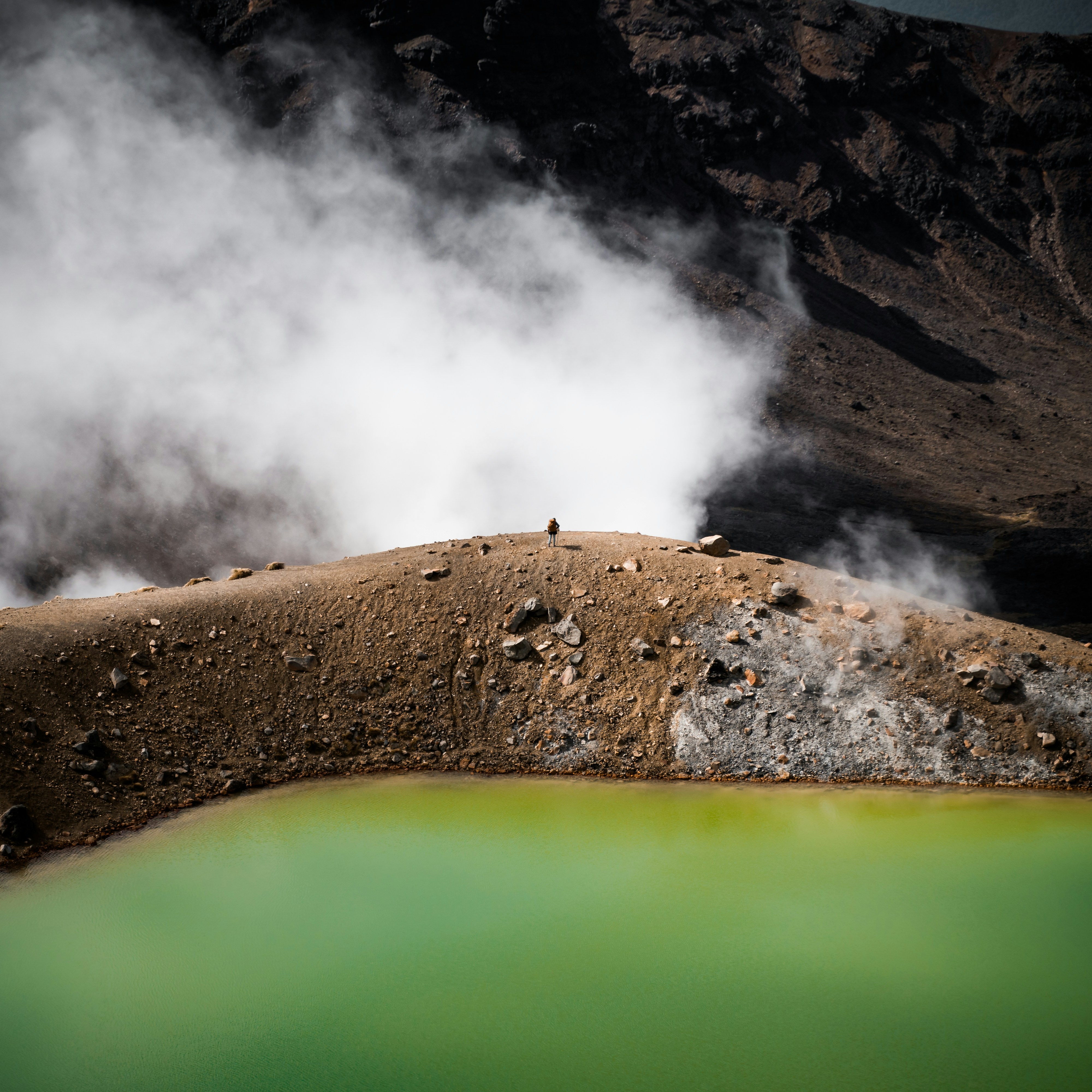 Hiker standing at the edge of the steaming Boiling Lake in Dominica