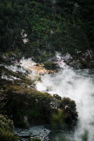 Atmospheric shot of the Furnas geothermal steam rising over lush Azorean landscape.
