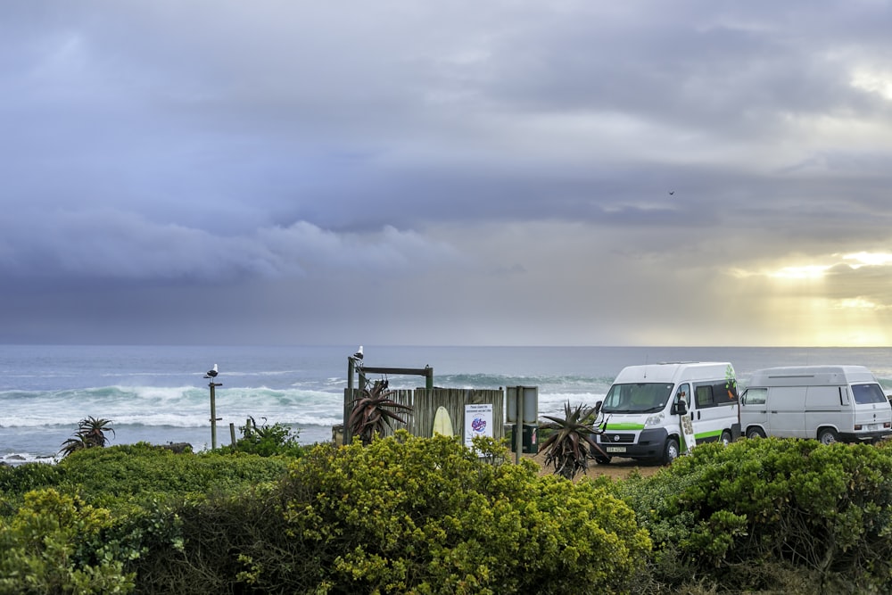 a group of vehicles parked next to a body of water