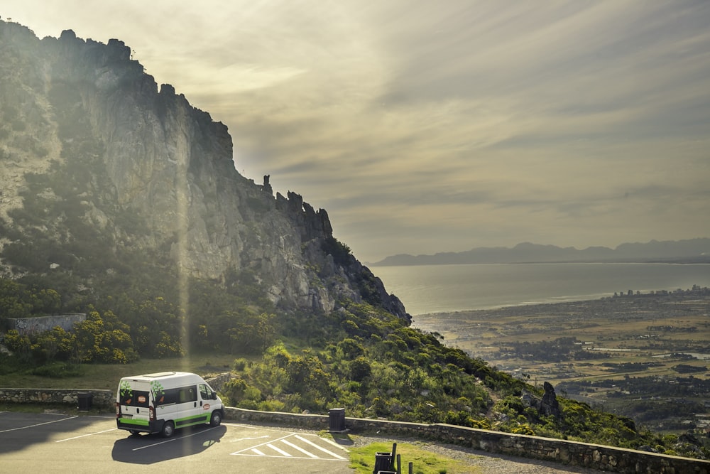 a bus driving on a road next to a cliff