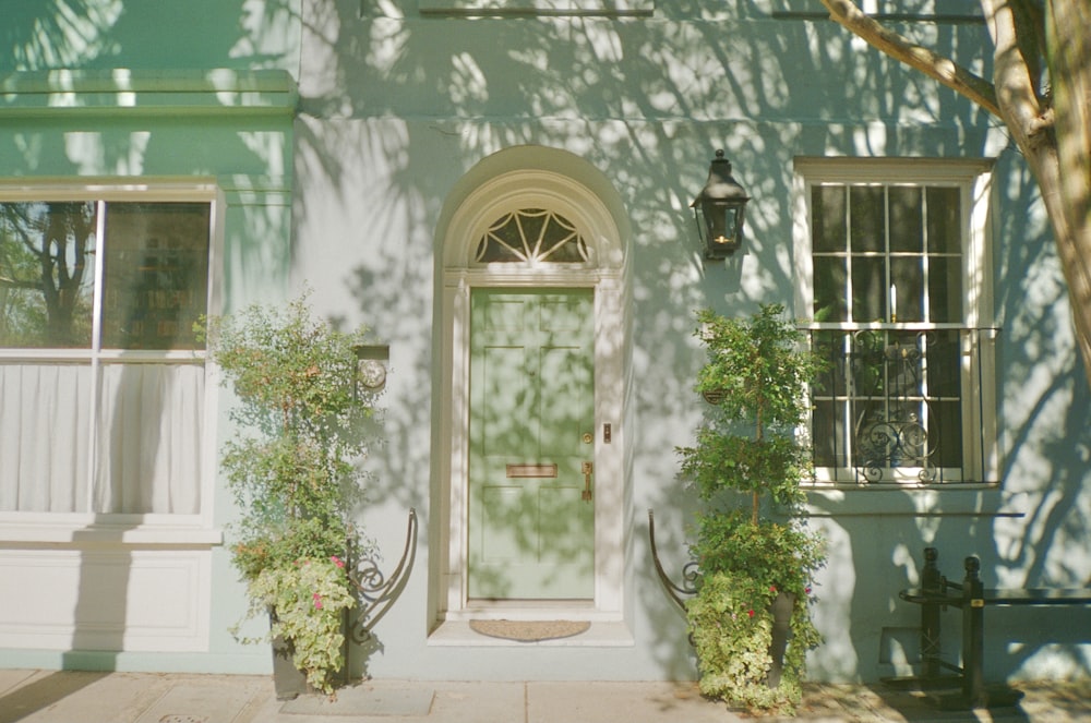 une maison avec une porte et des plantes devant elle