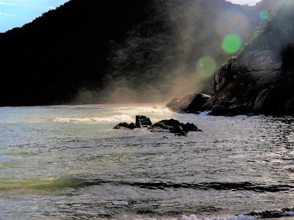 a body of water with a large explosion in the distance