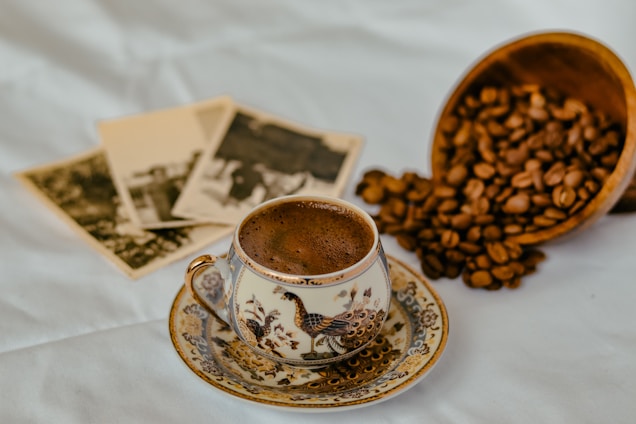 A beautifully arranged coffee cup with coffee beans and a scenic backdrop.