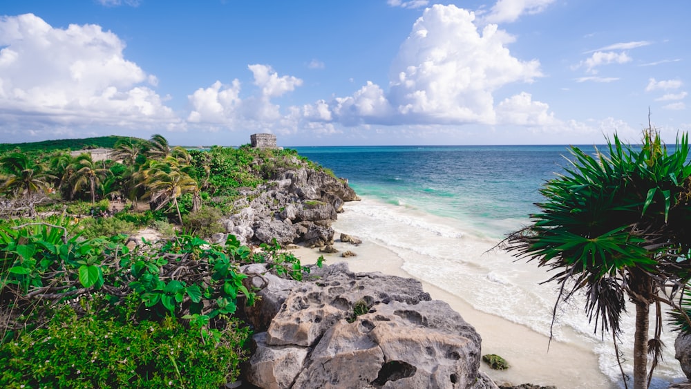 a rocky beach with Tulum on it