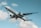 A large Emirates airplane soars through the sky with the landing gear retracted. The aircraft is prominently branded with the Emirates logo and features a white body with red, green, and black markings on the tail. The sky is mostly clear with a few scattered clouds.
