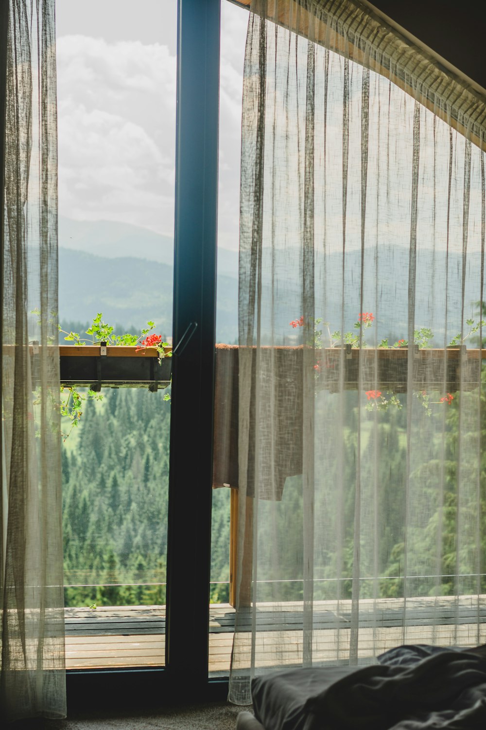 a window with a view of trees and mountains