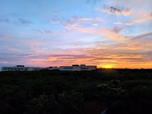 A vibrant sunset over a lush green landscape.