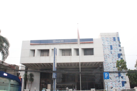 A bustling Bank BRI branch with friendly staff assisting diverse customers.