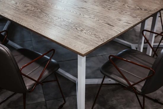 A set of modern metal chairs with geometric designs arranged around a wooden table.