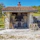 Outdoor wood-fired oven with rustic stone surroundings and kayaks by the river.
