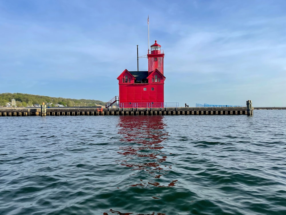 a red and white lighthouse on a pier