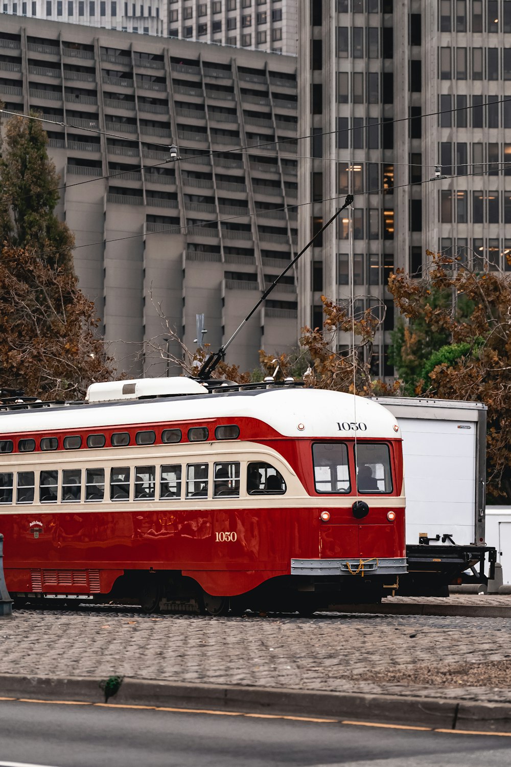a red and white trolley in front of a building