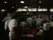 A bustling restaurant kitchen with chefs preparing meals for delivery.