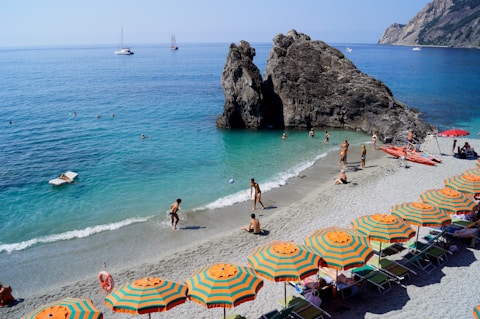 people on a beach with Monterosso al Mare in the background