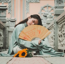 a person sitting on a ledge holding a book