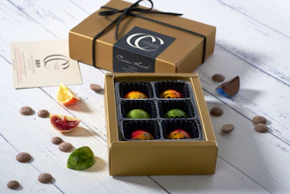 Close-up of assorted artisan chocolates arranged on a rustic wooden board with soft natural lighting.
