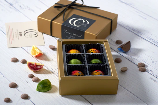 Close-up of assorted artisan chocolates arranged on a rustic wooden board with soft natural lighting.