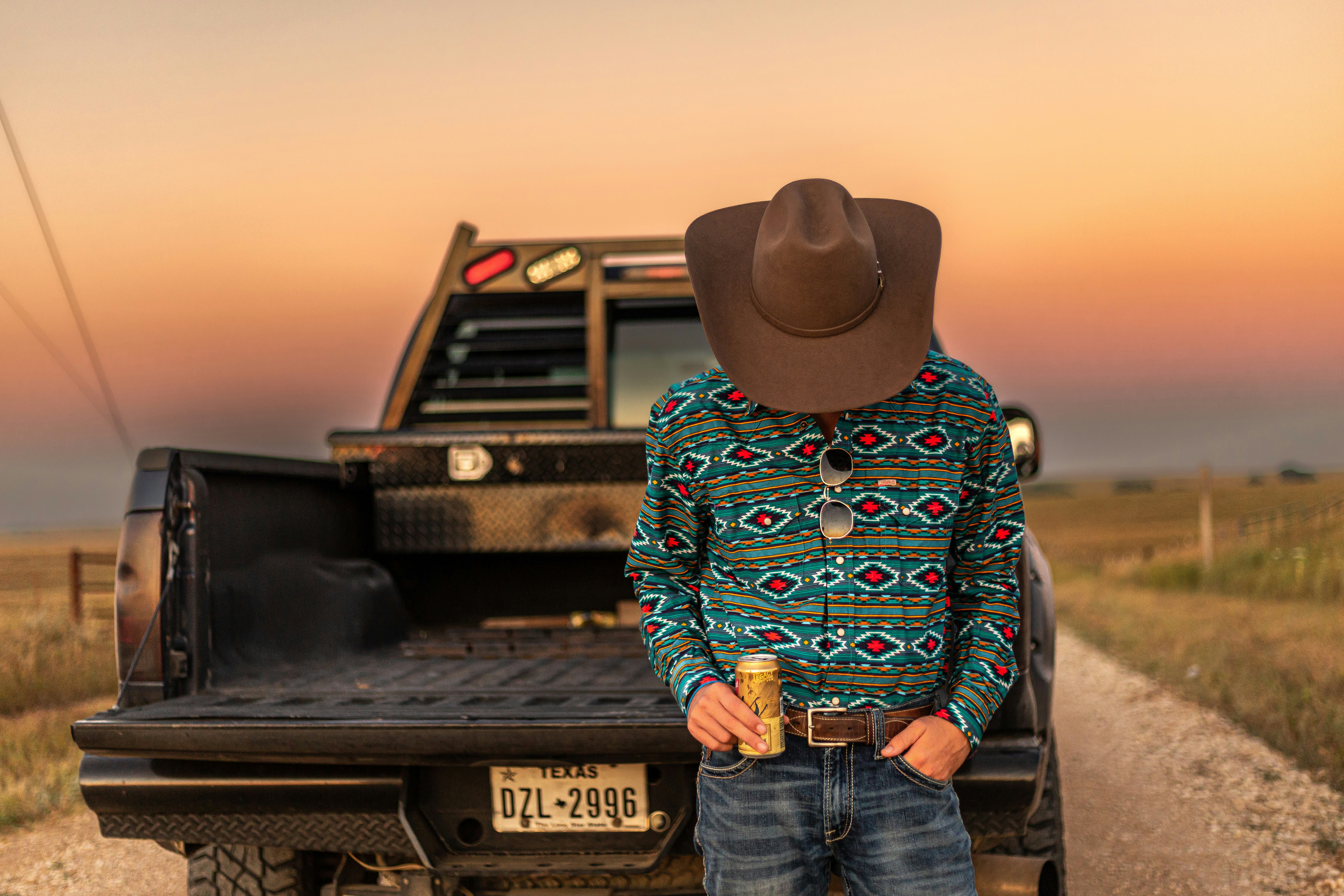 a person wearing a hat and standing in front of a truck