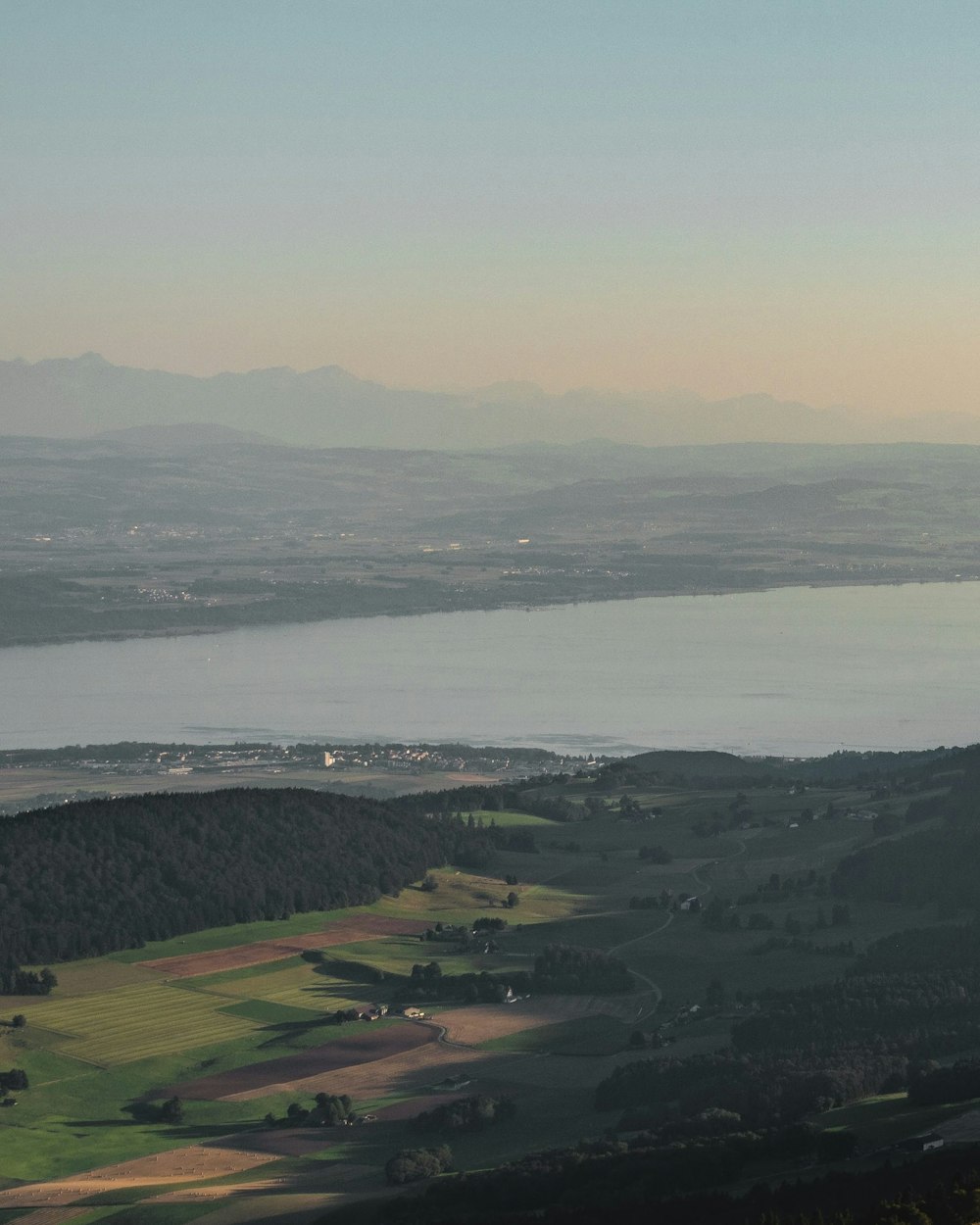 a landscape with a body of water and buildings in the back