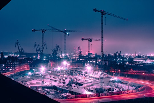 A bustling construction site illuminated by bright, energy-efficient LED lights at dusk.