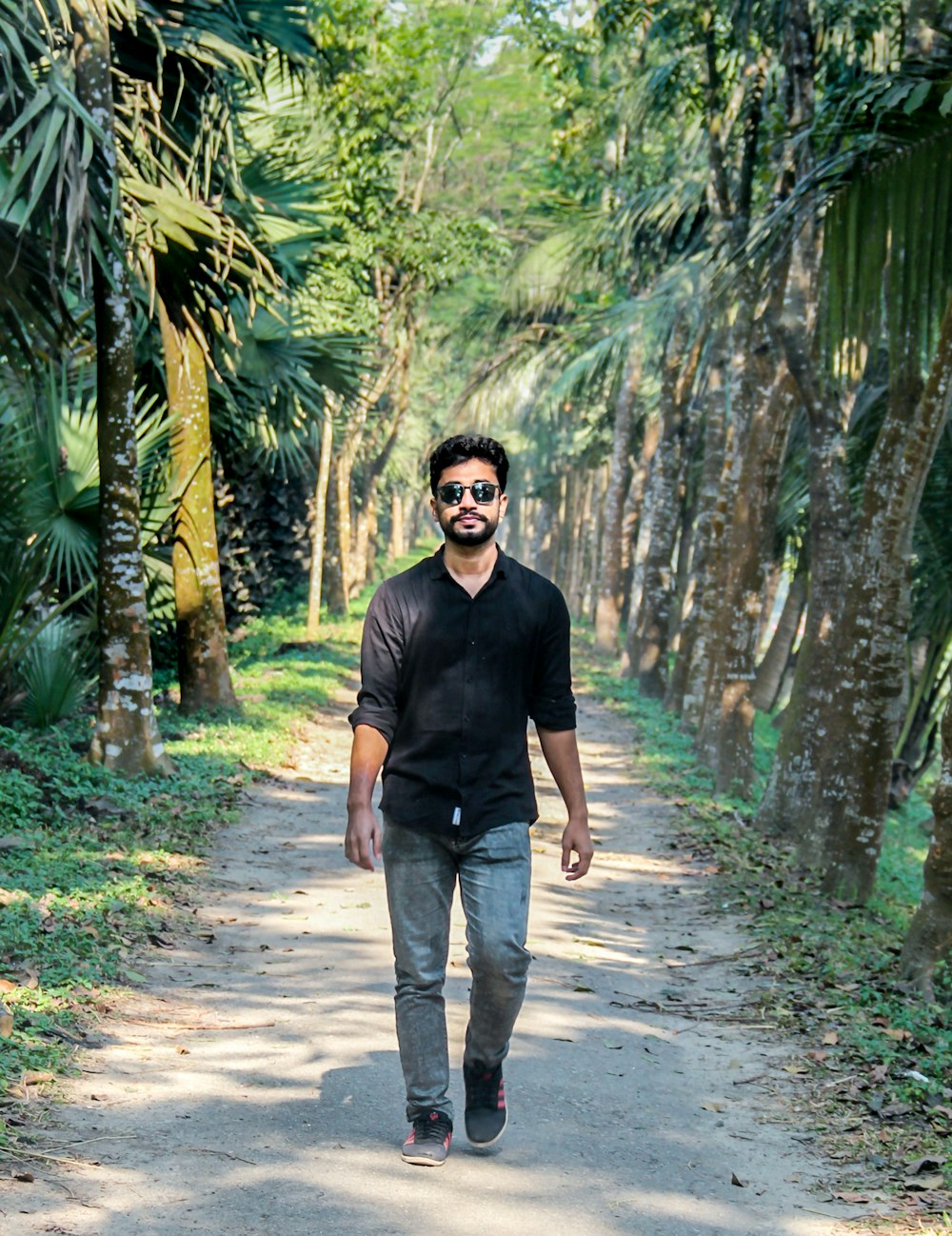 a man standing on a path surrounded by trees