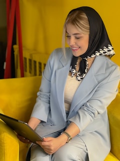 A smiling senior woman following an AI tutorial on her tablet in a cozy living room