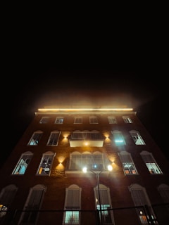 Evening shot of 631 S Front St with lit windows and street activity.