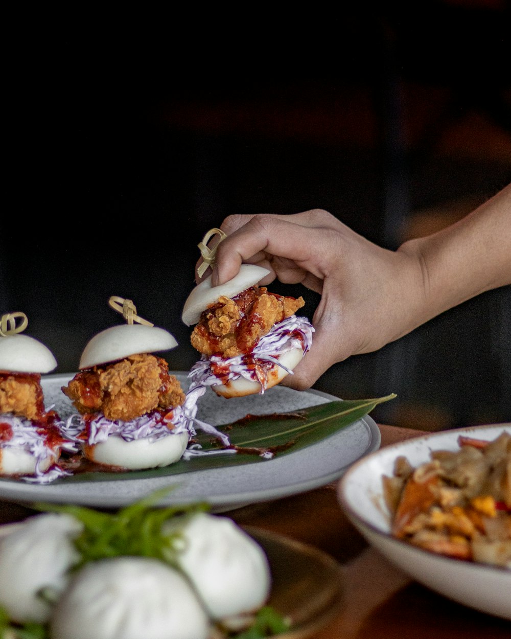 a hand holding a piece of sushi