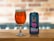 A can of 'Hercule Bergé Belgian DIPA' beer with a colorful label featuring an illustration of a character wearing a wide-brimmed hat is placed on a wooden surface next to a glass filled with amber-colored beer. The background is softly blurred, showcasing a brick pattern.