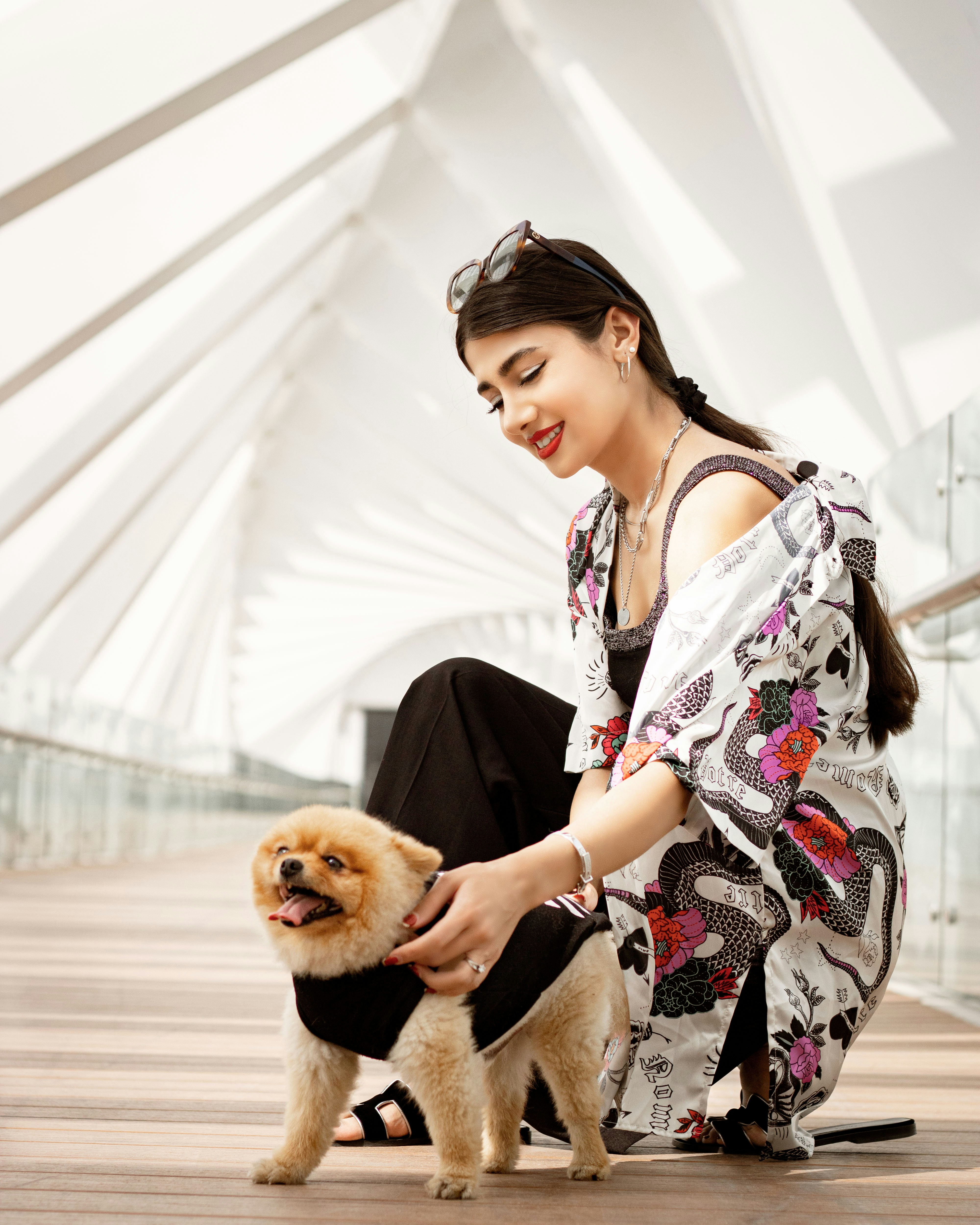 a woman sitting on a dock with a dog