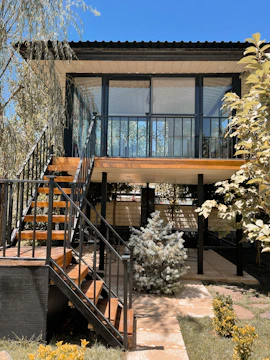 A compact annex with steel frame and large windows nestled in a garden.
