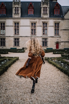 a person sitting on a rock in front of a building